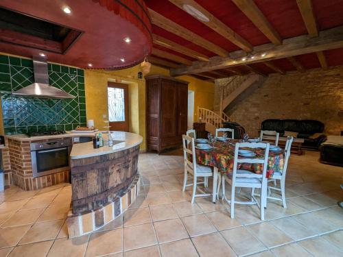 a kitchen with a table and chairs in a room at Gîte avec Piscine Chauffée, Jacuzzi et Jardin Privé - FR-1-653-156 in Charras