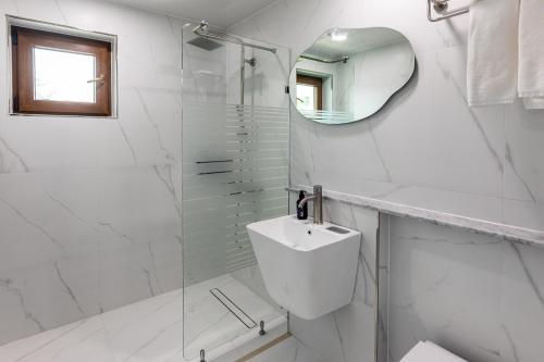 a white bathroom with a toilet and a mirror at Aewol Oceanstay in Jeju