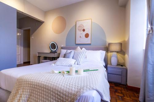 a bedroom with a white bed with two candles on it at Star Regency by Plush in Brinchang