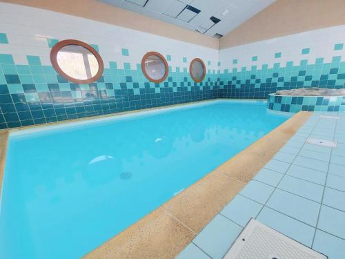 une grande piscine avec deux miroirs sur le mur dans l'établissement Appartement lumineux avec piscines, terrasse et parking à Samoëns - FR-1-624-125, à Samoëns