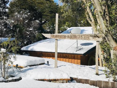 a sign in the snow in front of a building at Kingfisher de los Andes in Villa Meliquina