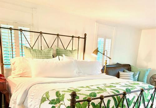 una camera da letto con un grande letto con cuscini verdi e bianchi di Plantation House Bed & Breakfast a Port Hope