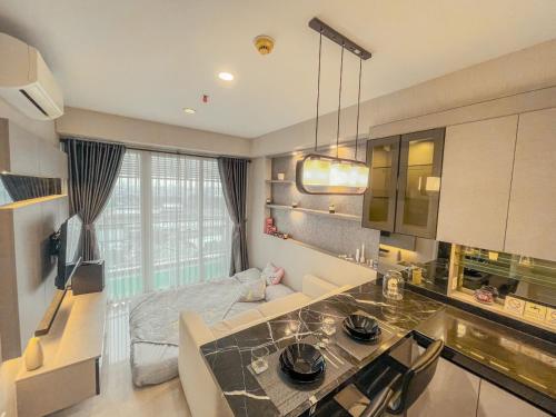 eine Küche und ein Wohnzimmer mit einem großen Fenster in der Unterkunft B Landmark Residence in Bandung