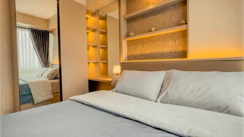 B Landmark Residence في باندونغ: غرفة نوم بسرير ومرآة
