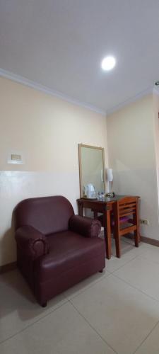 a living room with a couch and a mirror at Hotel Celebes in Manado