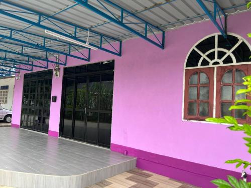a pink building with black doors and a window at Roomstay Budget Kuala Terengganu Desa Chendering Private Bathroom in Kuala Terengganu