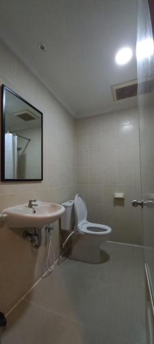 a bathroom with a sink and a toilet and a mirror at Hotel Celebes in Manado