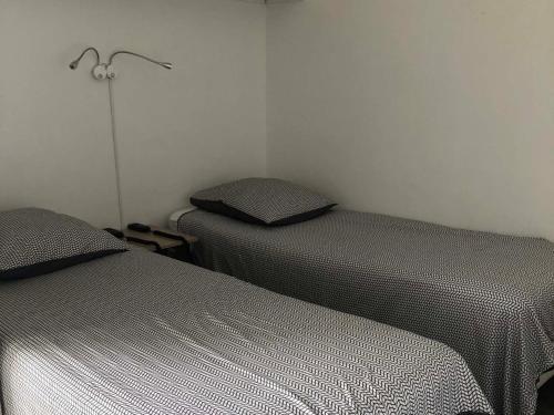 dwa łóżka ustawione obok siebie w pokoju w obiekcie Appartement avec Balcon Proche des Thermes, Étang et Commerces - Climatisé, Animaux Admis - FR-1-503-134 w mieście Balaruc-les-Bains