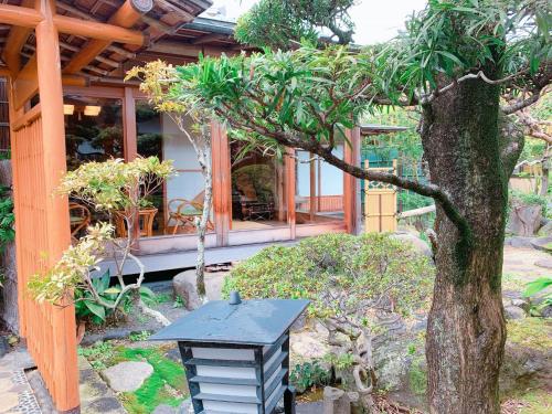 a black table in front of a house with a tree at KOUBOUNOYU IKONASOU in Shizuoka