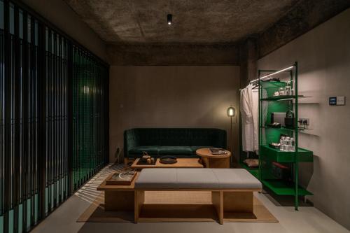 a living room with a green couch and a table at Jiangnan House Nantou in Shenzhen