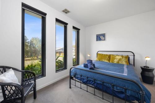 een slaapkamer met een bed en grote ramen bij Sea View Beach House 11a in Torquay