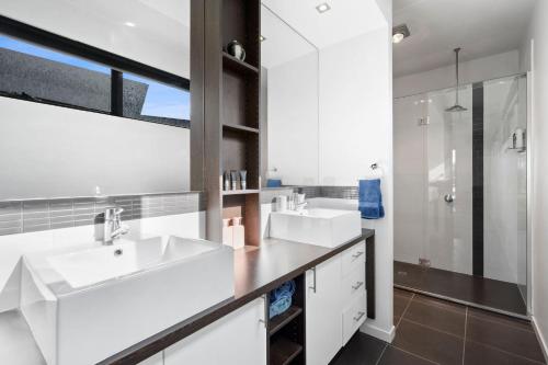 een badkamer met 2 wastafels en een douche bij Sea View Beach House 11a in Torquay