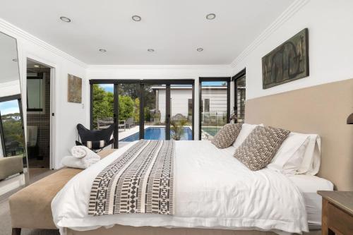 a bedroom with a large bed and a pool at Araluen House Werri Beach Gerringong in Gerringong