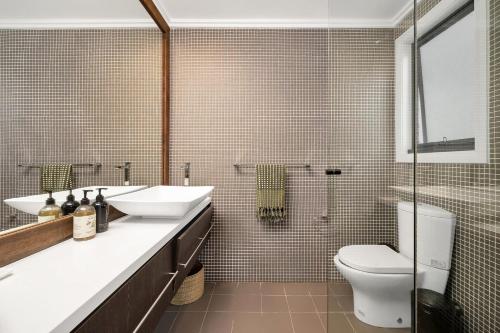 a bathroom with a sink and a toilet and a shower at Araluen House Werri Beach Gerringong in Gerringong