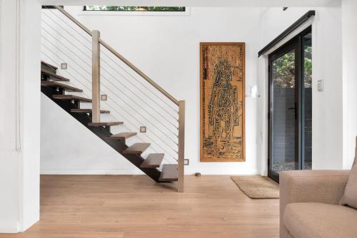 a living room with a staircase and a door at Araluen House Werri Beach Gerringong in Gerringong