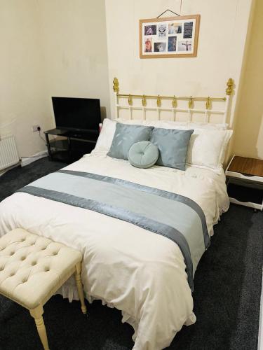 um quarto com uma cama grande e um banco ao lado em Double Bedroom in West Yorkshire, Leeds em Hunslet