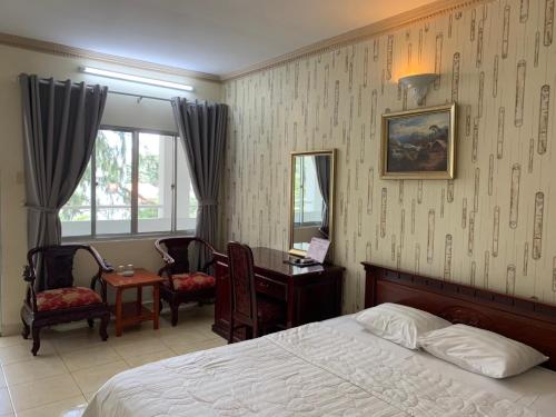 头顿林宋酒店的一间卧室，里面有一张床、一张桌子和一扇窗户。