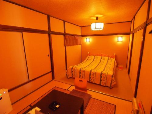 a small room with a bed and a table at ホテルセーラ赤堀店 