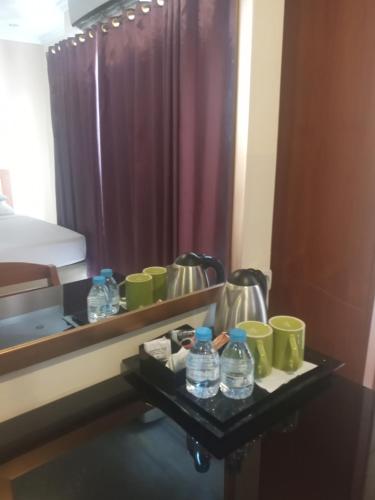 Hotel Celebes في مانادو: غرفة الفندق مع طاولة عليها زجاجات الماء