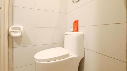 a bathroom with a toilet with an orange sign on it at RedDoorz La Sefa Hotel and Resort Atimonan in Atimonan