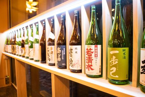 a row of bottles of wine sitting on a shelf at Iizaka Onsen Surikamitei Ohtori in Fukushima