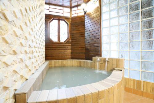 a hot tub in a room with a large window at Phoenix Pavilion Hot Spring Hotel in Taipei