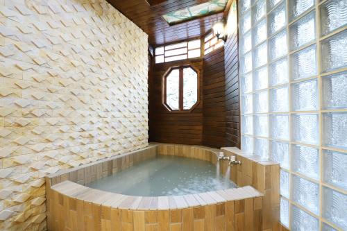 a bath room with a tub and a window at Phoenix Pavilion Hot Spring Hotel in Taipei