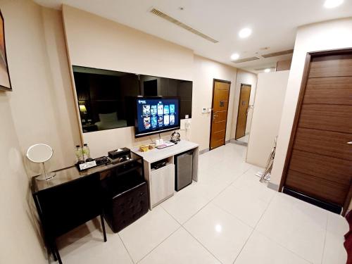 a large room with a kitchen with a television at Sa-Yo Hotel - Pier 2 in Kaohsiung