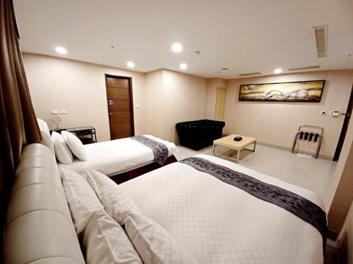 a hotel room with two beds and a couch at Sa-Yo Hotel - Pier 2 in Kaohsiung