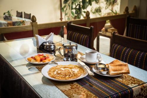 a table with a breakfast of pancakes and fruit on it at Hotel Yambu kathmandu in Kathmandu