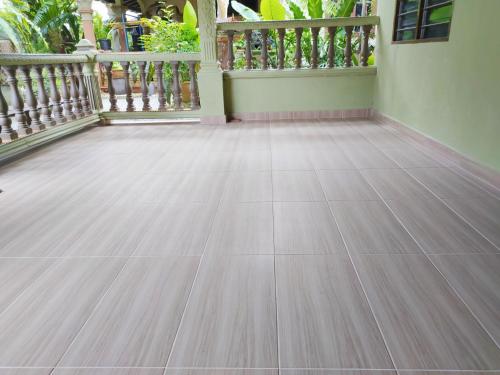 a room with a wooden floor and a balcony at Hidden Homestay in Marang