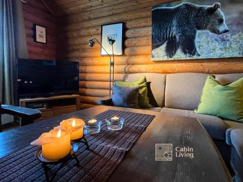 ein Wohnzimmer mit einem Tisch und einem Bärengemälde an der Wand in der Unterkunft Cozy cottage in central Beitostølen with Sauna in Beitostøl