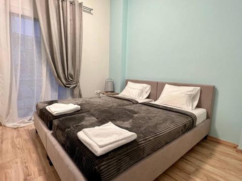 um quarto com uma cama grande com duas toalhas em ALEX Suite with 2 bedrooms vipgreece em Atenas