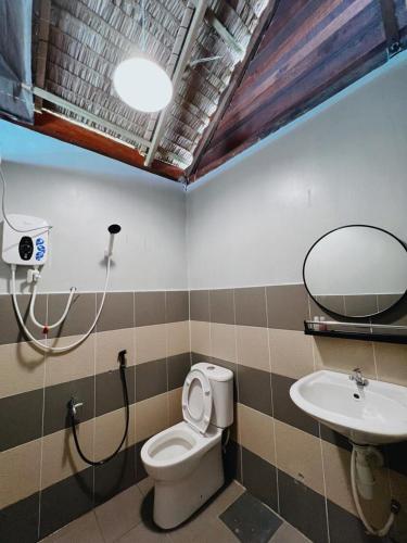a bathroom with a toilet and a sink at Nipoh Beach Cottage in Kijal