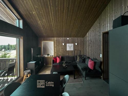 ein Wohnzimmer mit Sofa und Tisch in der Unterkunft Cozy Apartment electric car charger & ski in out Sjusjøen in Sjusjøen