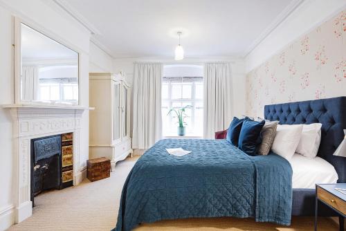 a bedroom with a blue bed and a fireplace at ARCORE Premium Apartments Broad Court in London