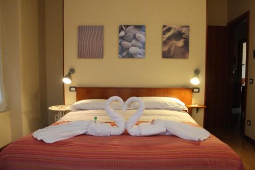 deux cygnes faits de serviettes assis sur un lit dans l'établissement Affittacamere La Branda, à La Spezia