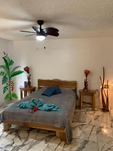 a bedroom with a bed and a ceiling fan at Casa Mambo in Cahuita
