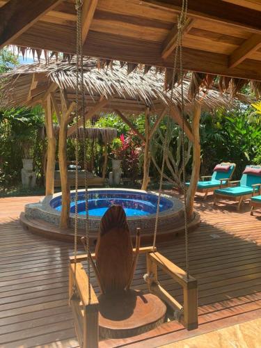 a deck with a swing and a swimming pool at Casa Mambo in Cahuita