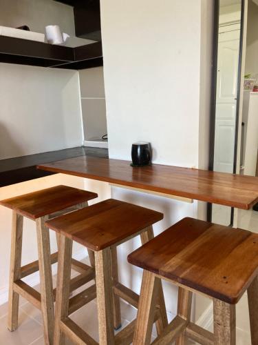 a kitchen with two wooden tables and two stools at B123 Unit 1852 Prime Residences Tagaytay Condominium - Budget Staycation - Not 5-star Hotel Accommodation in Tagaytay