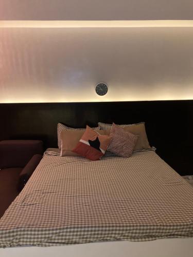 a bed with a checkered blanket and pillows on it at B123 Unit 1852 Prime Residences Tagaytay Condominium - Budget Staycation - Not 5-star Hotel Accommodation in Tagaytay