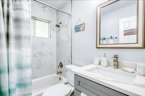 uma casa de banho com um lavatório, um WC e um espelho. em Deerfield Beach in Style em Deerfield Beach