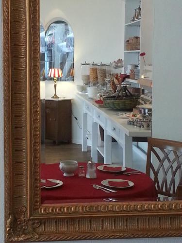 a mirror reflecting a kitchen with a table with red plates at Weinstadt Hotel - das Original in Weinstadt