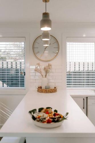 a white kitchen with a bowl of food on a counter at Water's Edge in Culburra Beach