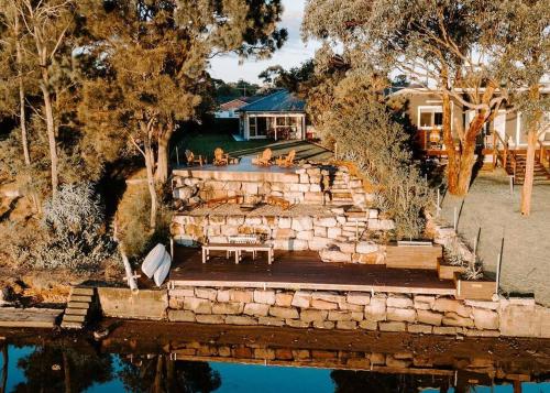 an aerial view of a house with a stone stairs and water at Water's Edge in Culburra Beach