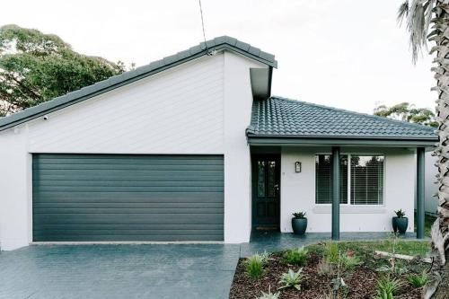 a garage door on a white house at Water's Edge in Culburra Beach