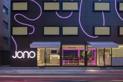 a store with neon signs on the side of a building at Jono Bangkok Asok Hotel in Bangkok
