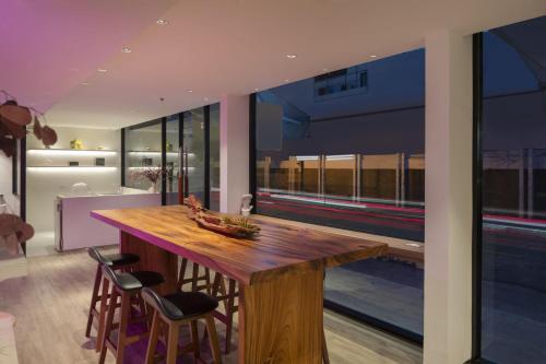 a kitchen with a wooden table and some chairs at Jono Bangkok Asok Hotel in Bangkok