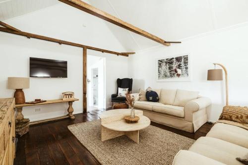 uma sala de estar com um sofá e uma mesa em Picturesque Barn located on the Shoalhaven River em Nowra