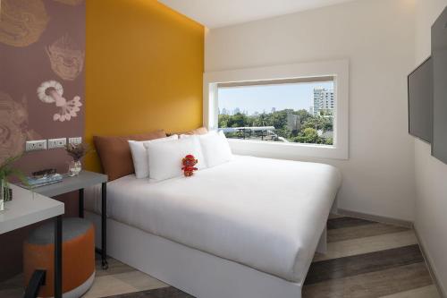 a bedroom with a white bed and a window at Jono Bangkok Asok Hotel in Bangkok